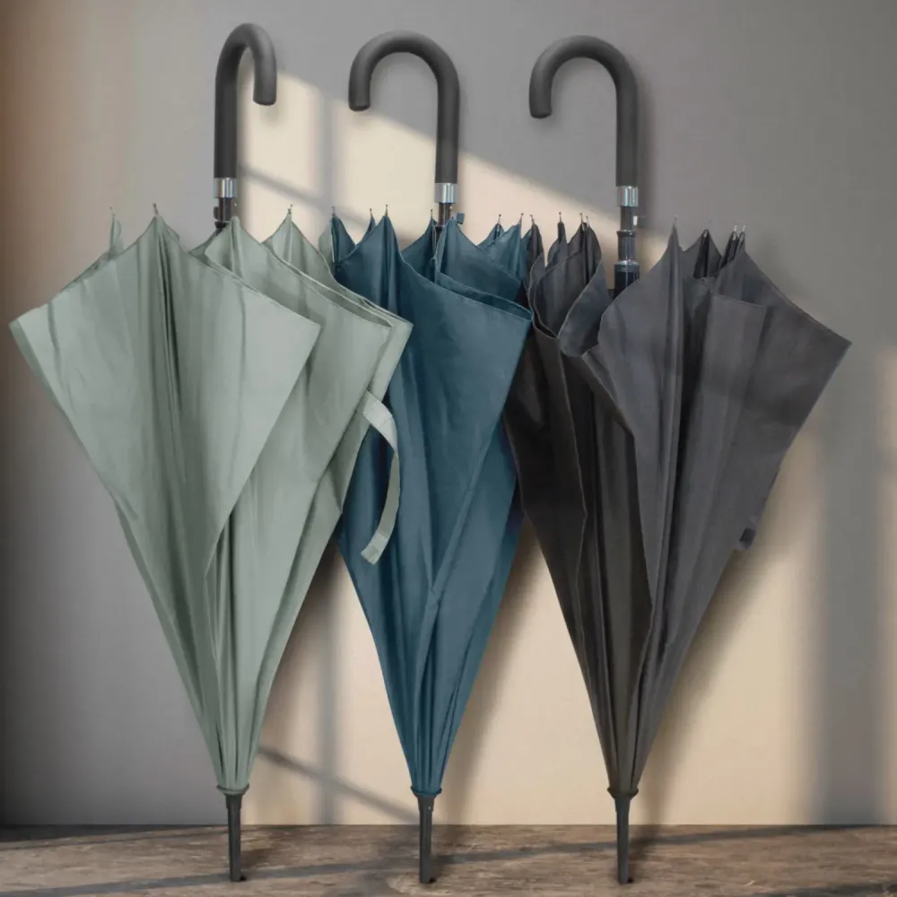 Pegasus Hook umbrellas in grey, navy, and black, closed with curved handles hanging on wall