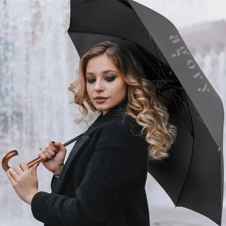 Person holding Executive umbrella in black, open underside view with branded panel