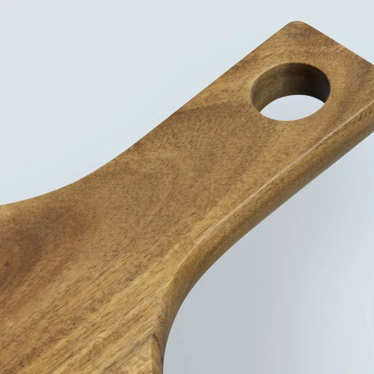Close-up of acacia wood pizza board handle with smooth finish and hanging hole.