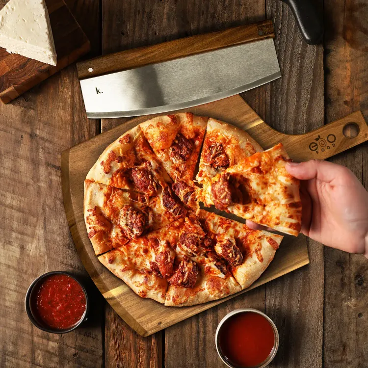 Wooden pizza board with fresh pizza, stainless steel cutter, and branded handle displayed on rustic table.
