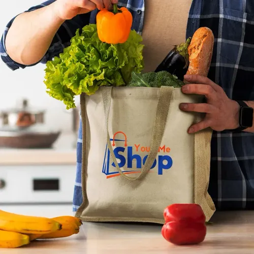 Horus Tote Bag in natural cotton with jute sides and long handles, printed logo, filled with fresh groceries.