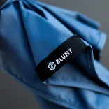 Close-up of BLUNT Coupe umbrella canopy showing stitched edge and black branded label with BLUNT logo