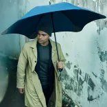 Person walking in rain holding BLUNT Exec umbrella in midnight navy colour