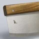 Close-up of stainless steel pizza cutter blade with acacia wood handle and engraved k logo.