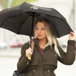 Person holding RPET Compact umbrella in black with printed logo on one panel